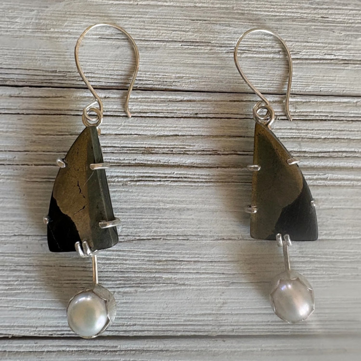 Paarisha Jewelry dangle earrings featuring triangular pyrite stones and dangling white pearls on silver hooks.